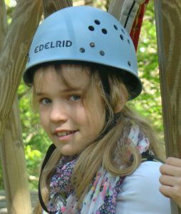 Mädchen mit blauem Helm im Stangenwald im Kletterwald BinzProra
