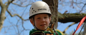 Junge mit Helm beim Klettern