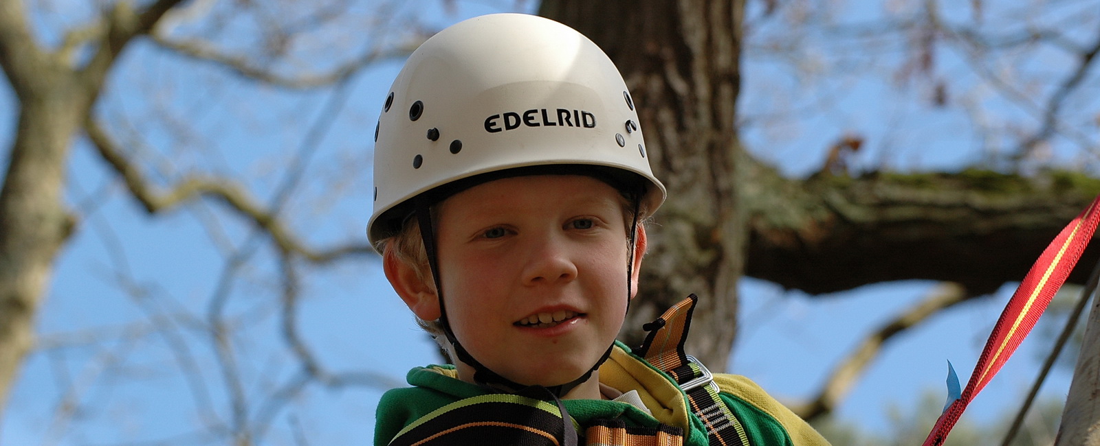 Junge mit Helm beim Klettern